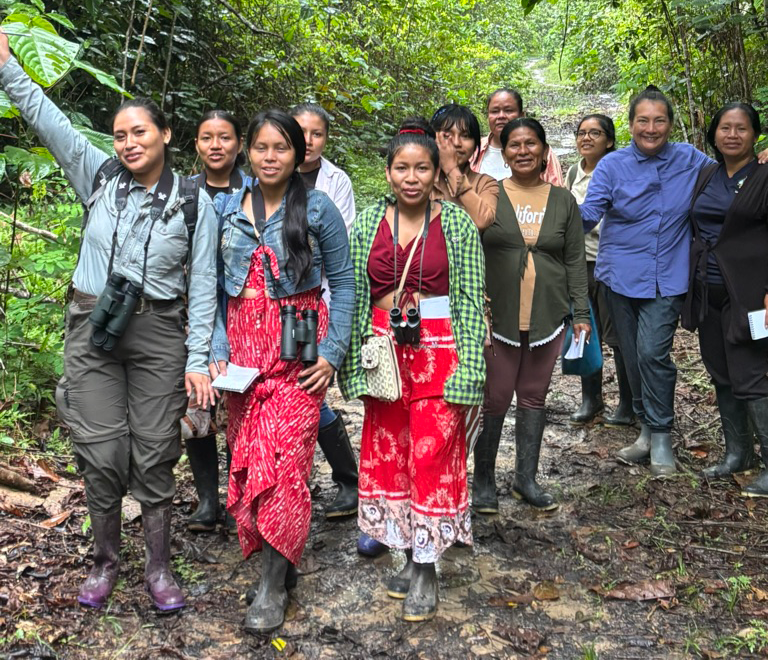 Women from Kukama communities walking through the Amazon rainforest during a birdwatching workshop