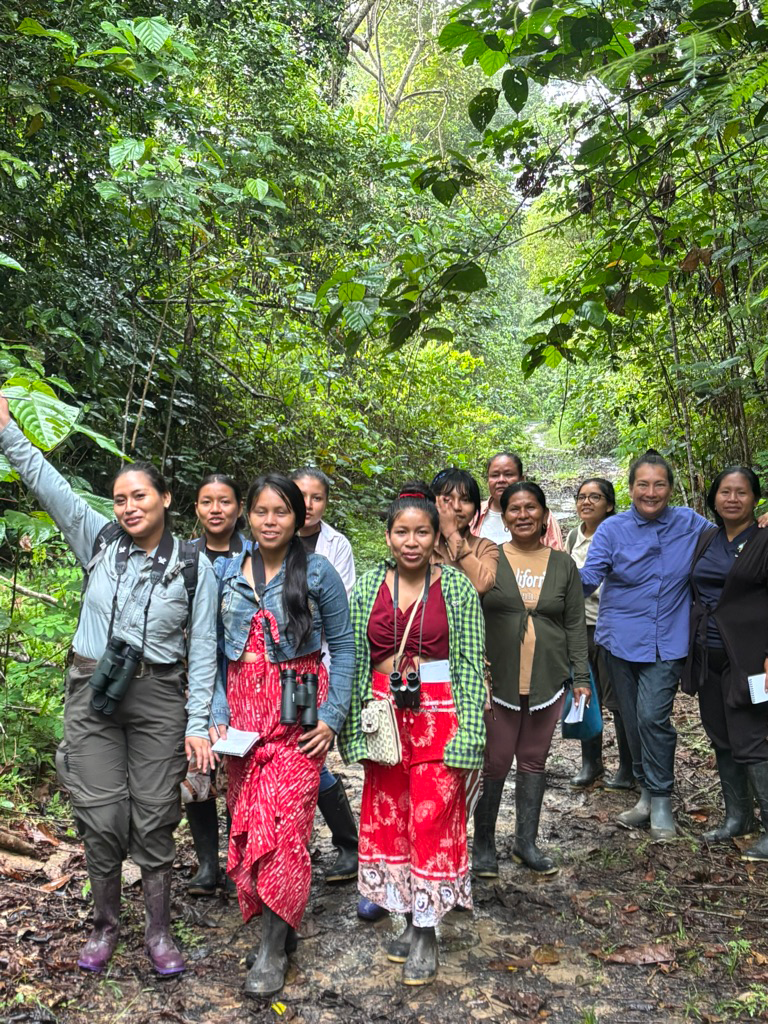 Women from Kukama communities walking through the Amazon rainforest during a birdwatching workshop