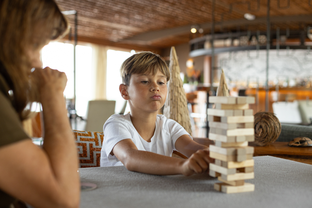 Child playing a wooden game inside the lounge of Delfín Amazon Cruises in the Peruvian Amazon