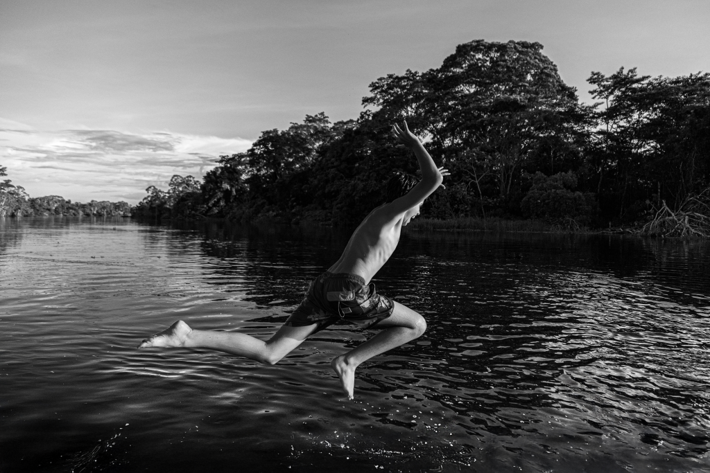 Child jumping into the Amazon River during an excursion with Delfín Amazon Cruises