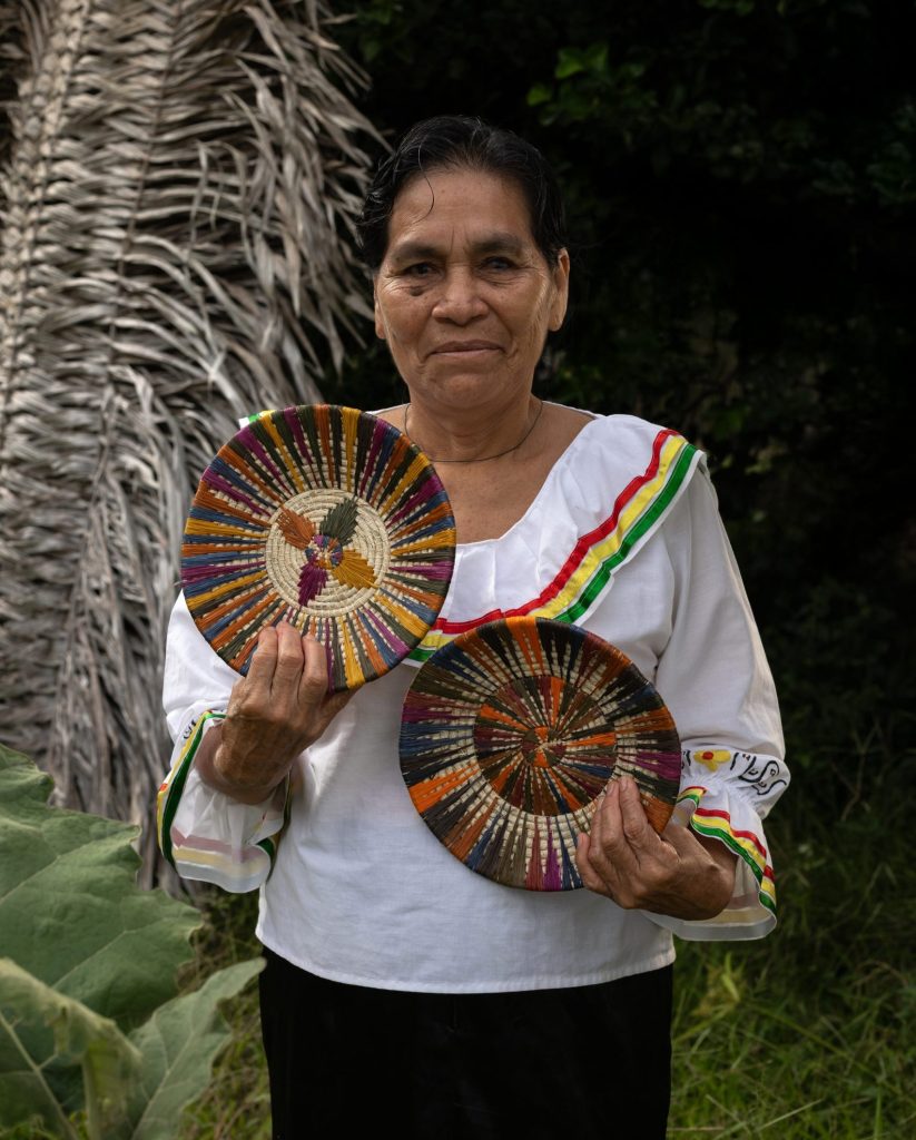 Amazon woman artisan holding handcrafted woven plates made from chambira fiber in the Peruvian rainforest