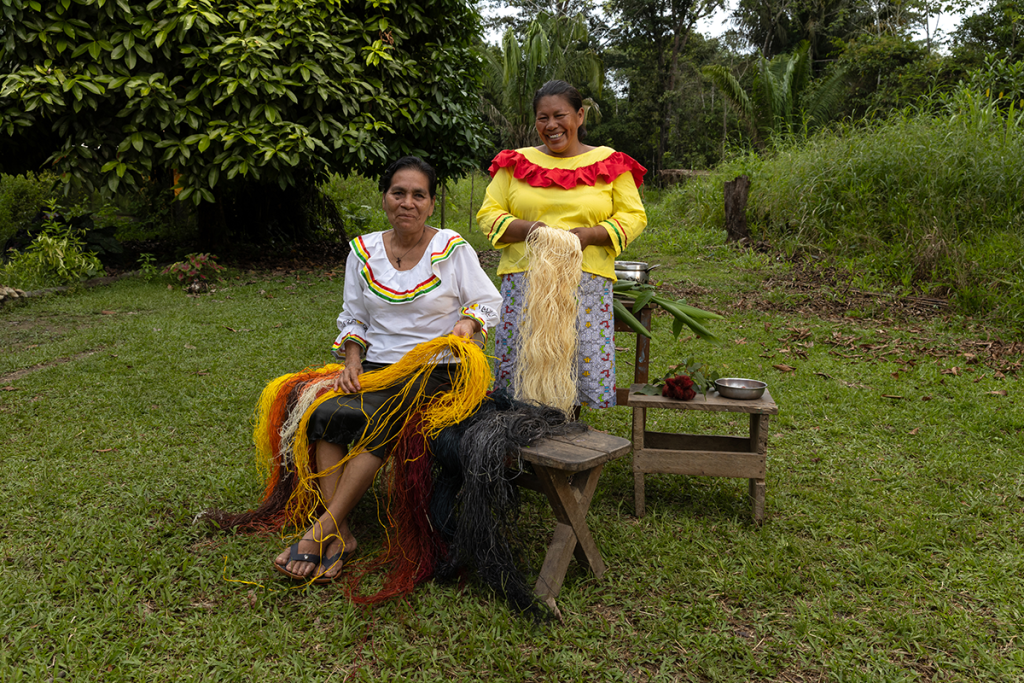 Amazon women weaving chambira fiber together in a community setting