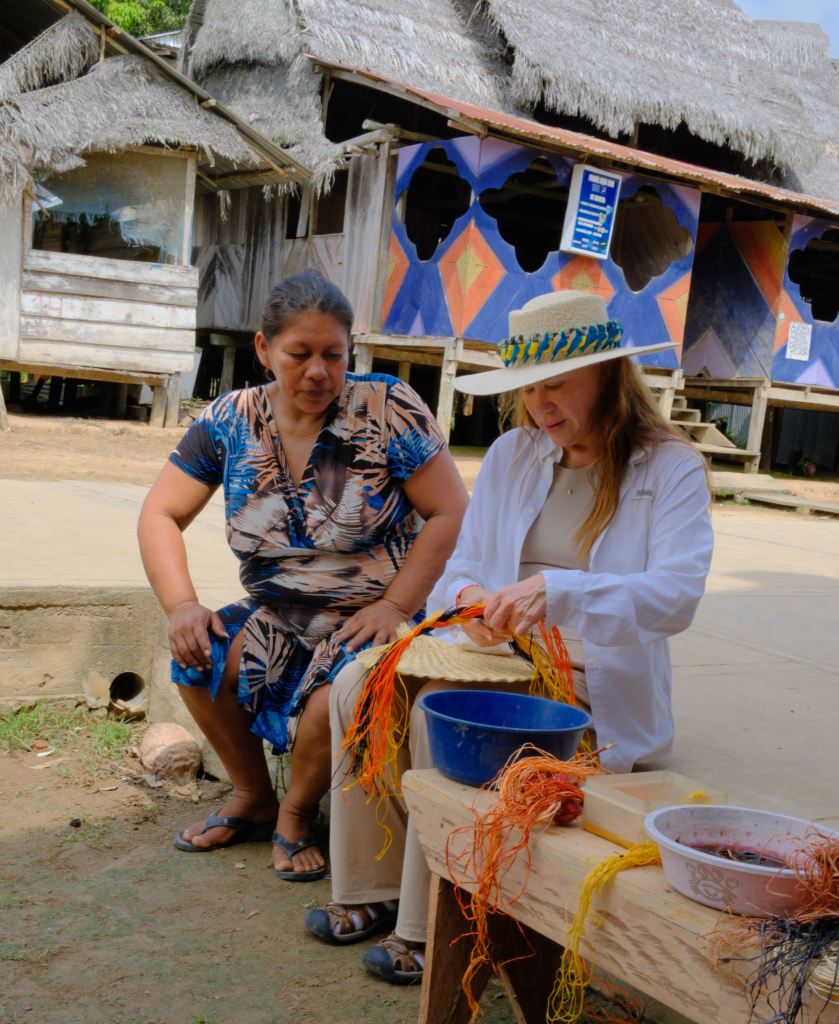 Lissy Urteaga working alongside an Amazon artisan during a community visit