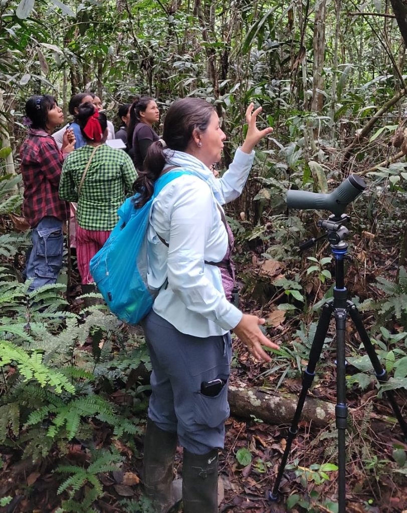Women learning birdwatching techniques in the Peruvian Amazon using binoculars and spotting scopes