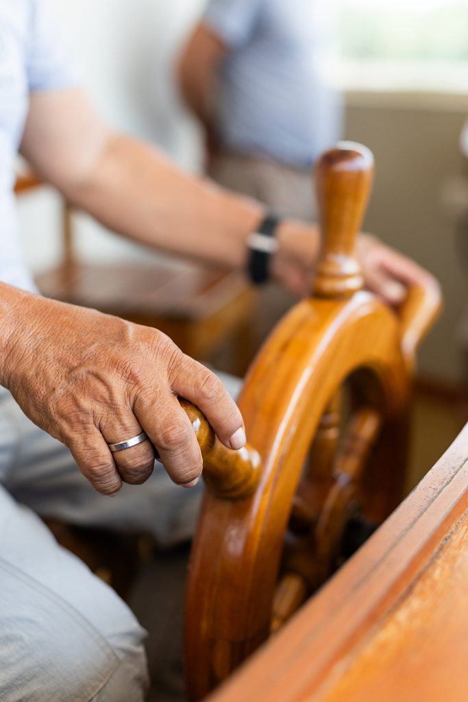 Hand steering a wooden wheel on a luxury river cruise boat in the Amazon
