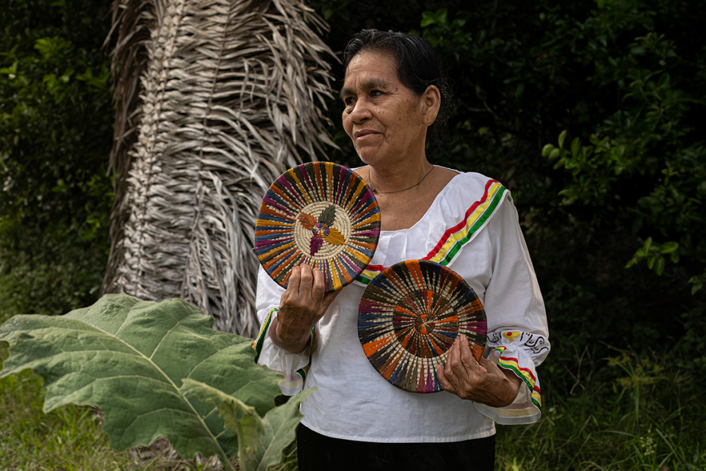 Amazonian artisan holding handcrafted woven plates made from natural fibers