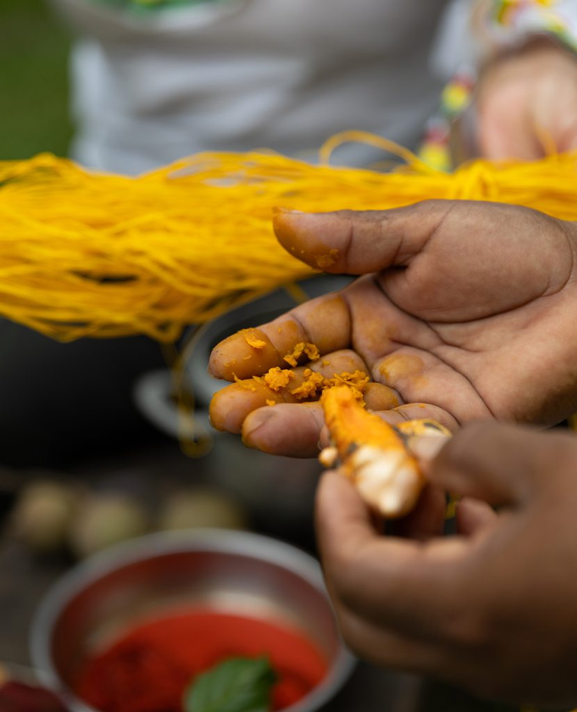 Hands extracting natural dye from Amazonian plant fibers used for traditional weaving