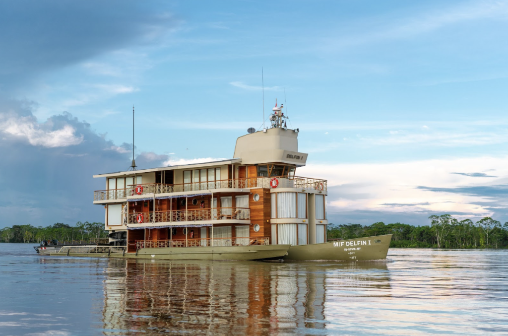 Delfín I luxury river cruise sailing in the Peruvian Amazon surrounded by rainforest and calm waters