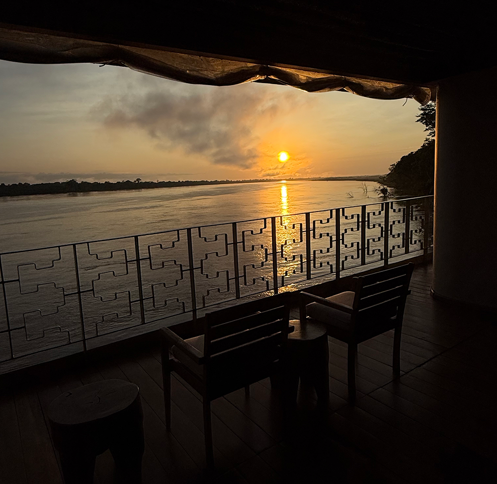Amazon river sunset viewed from a river cruise terrace with chairs facing the water