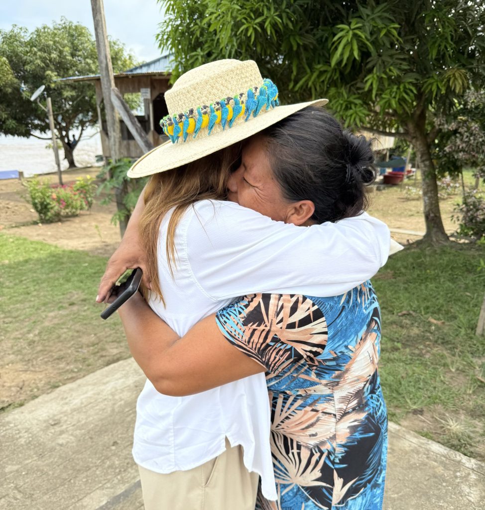 Lizzy sharing a warm embrace with an Amazonian artisan during a cultural visit