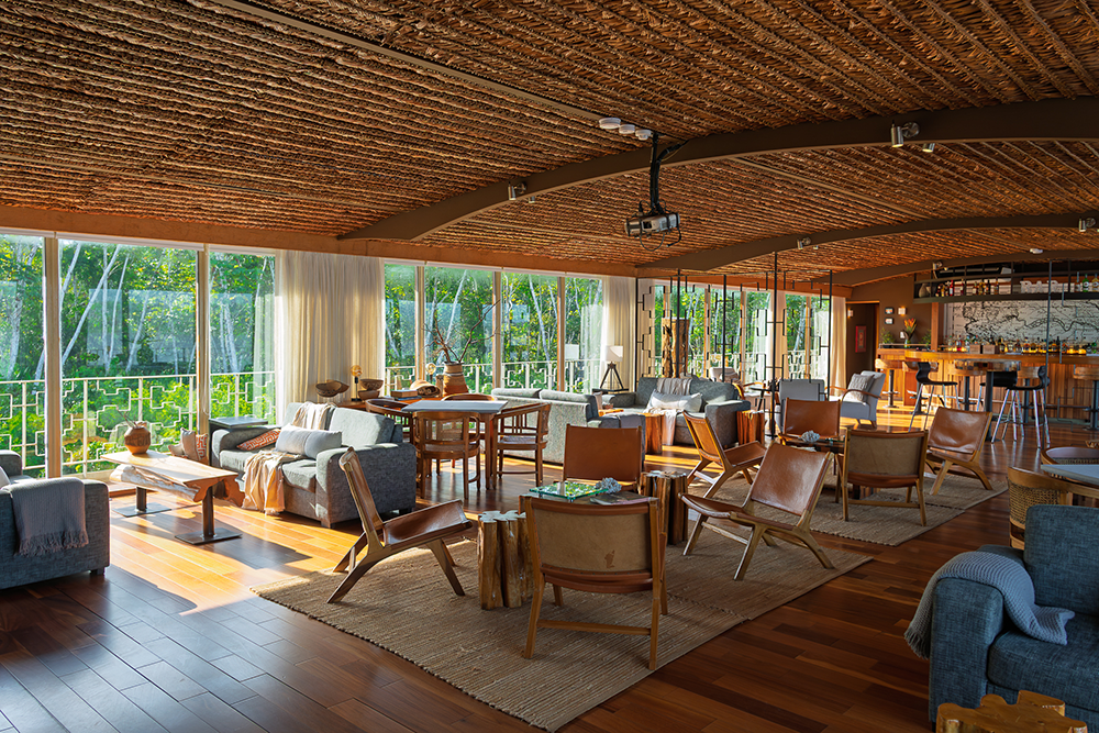 Luxury lounge area aboard Delfín Amazon Cruises with panoramic rainforest views in Peru
