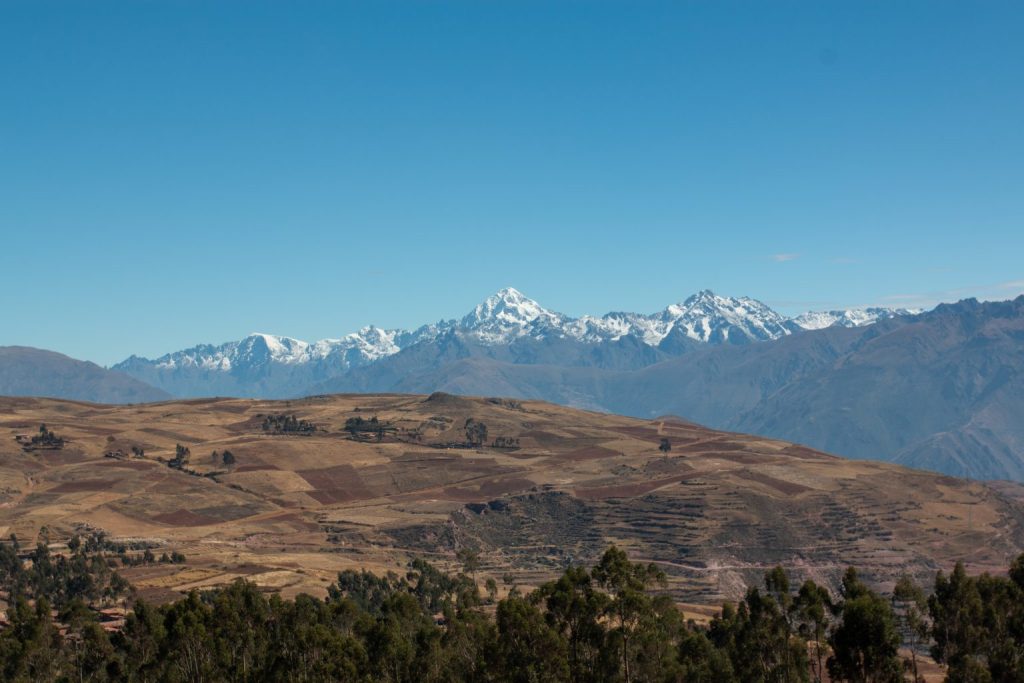 Snow capped Andes mountains rising above rural landscapes in Peru