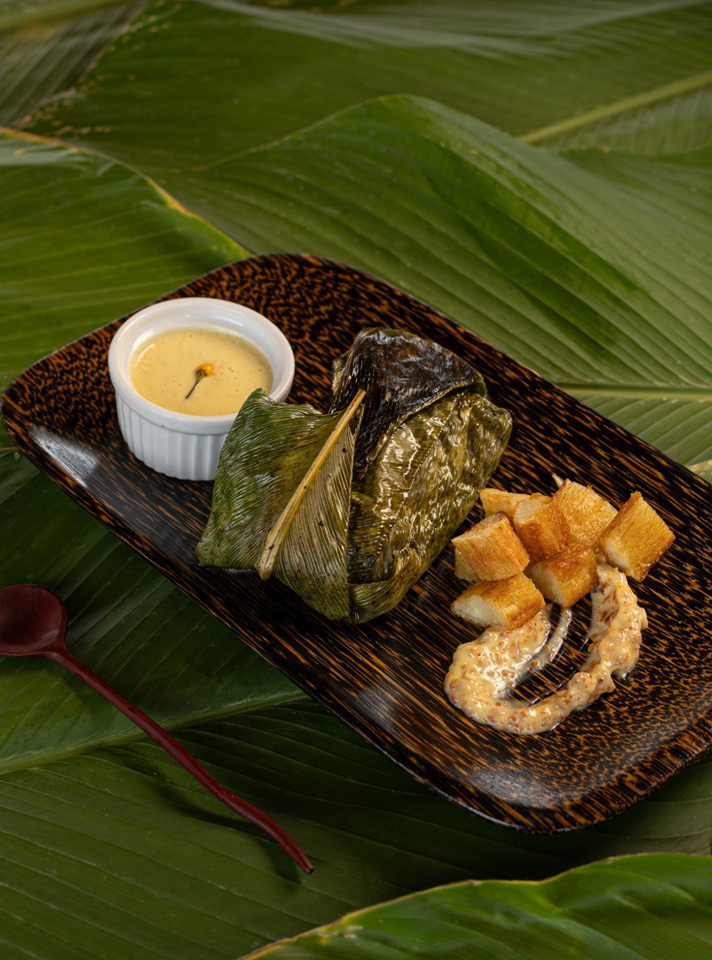 Amazonian fish dish wrapped in bijao leaf served at Delfín Amazon Cruises with local sides