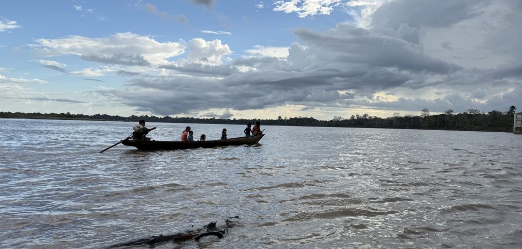 Amazon residents travelling in a wooden canoe on the river in Peru