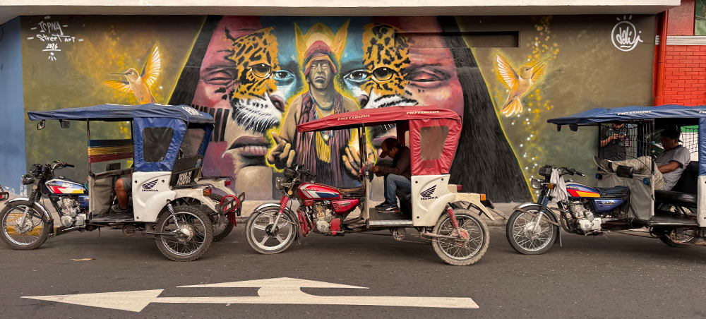 Motocarros in front of an Amazon-inspired mural in Iquitos, Peru